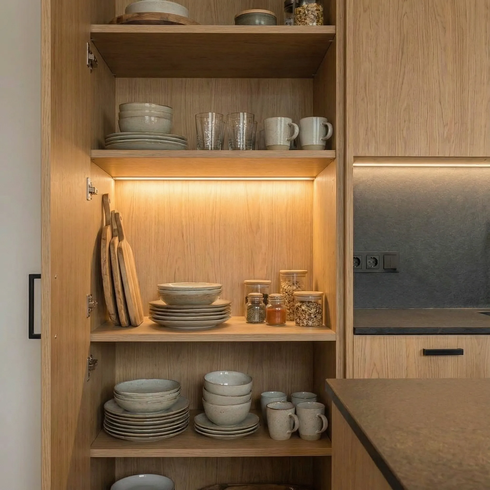 Otvoren kuhinjski element sa LED osvetljenjem i organizovanim posuđem